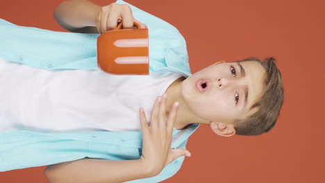 Vertical-video-of-The-boy's-mouth-is-burning-from-the-hot-drink.
